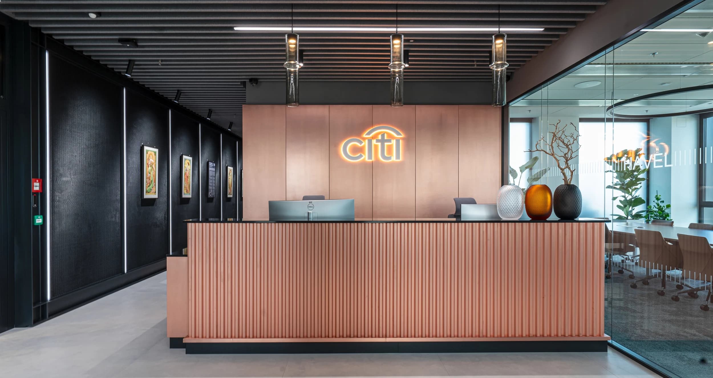 Recepce kanceláře Citibank v Praze s měděným lamelovým pultem, podsvíceným logem Citi a obrazy