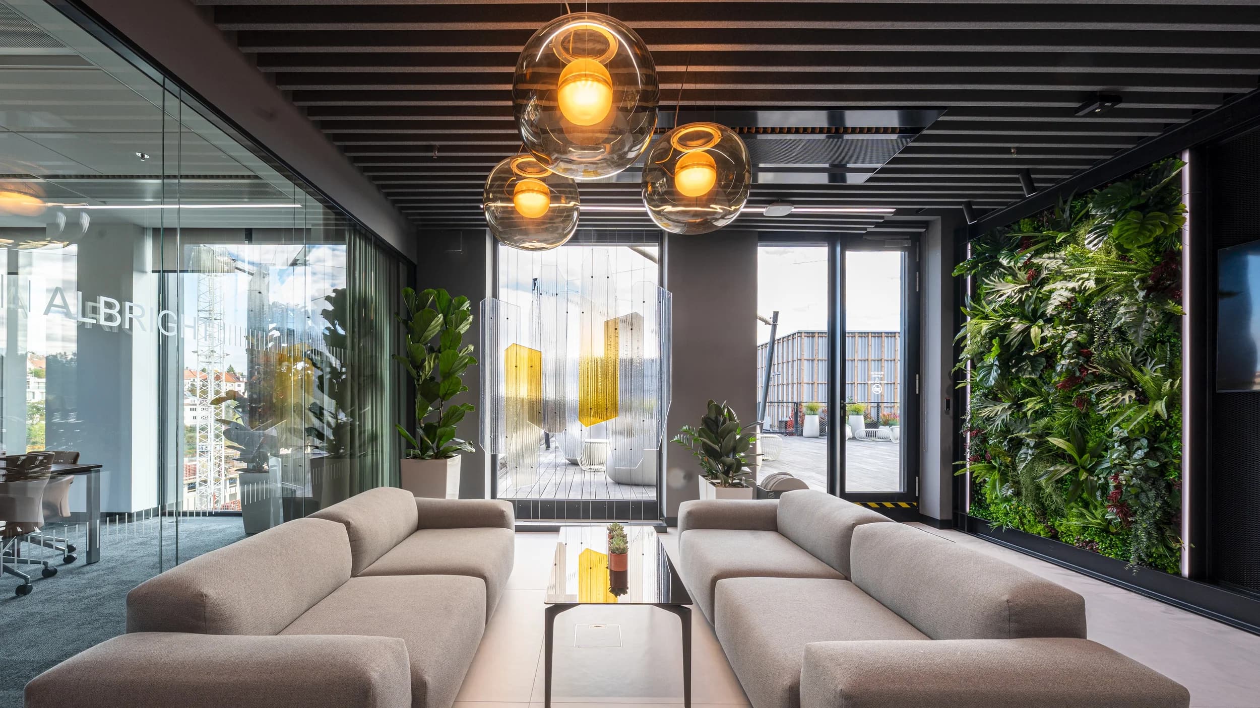 Lounge v kanceláři Citibank v Praze s béžovými pohovkami, skleněnými svítidly a zelenou stěnou z rostlin