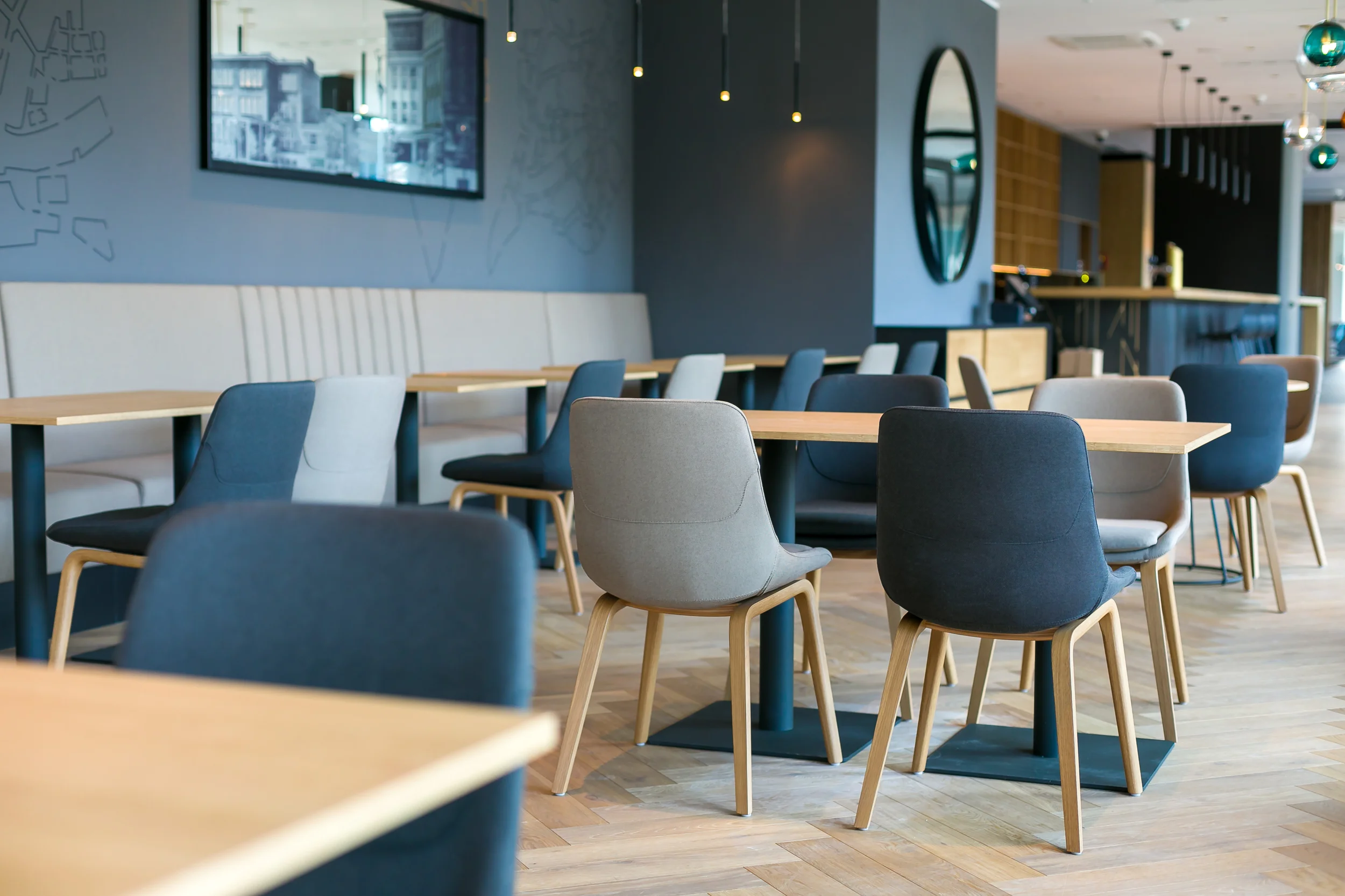 Restaurace Hotelu Aldis v Hradci Králové s modrými a šedými čalouněnými židlemi a dřevěnými stoly